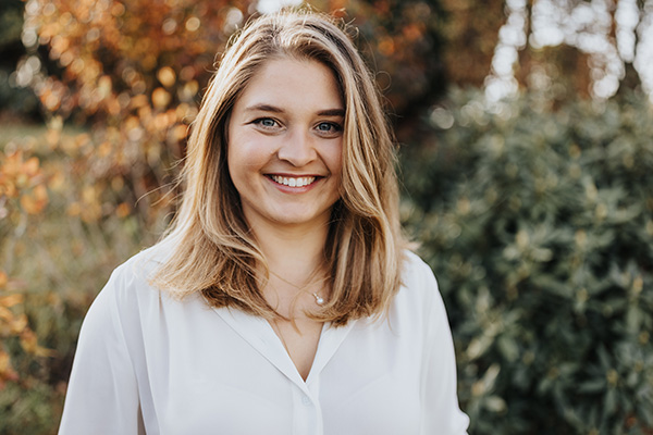 Das Bild zeigt die Coachin lachend im Garten.