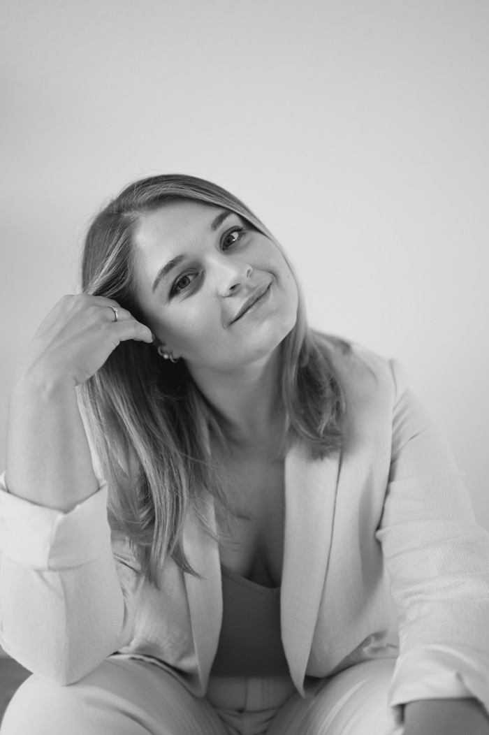 Das Bild zeigt die Coachin mit auf der Hand aufgestütztem Kopf in schwarz-weiß.